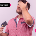 Pessoa segurando cartão e com a mão na testa.