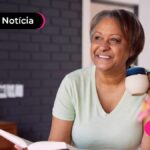 Pessoa de idade sorrindo após ler noticia sobre leilão do INSS.