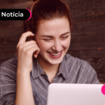Pessoa olhando para notebook com expressão feliz.