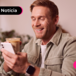 Pessoa olhando para celular com expressão sorridente.