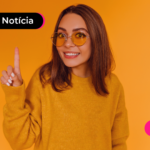 Pessoa de blusa amarela apontando para cima.