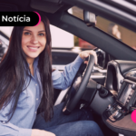 Pessoa em carro com expressão sorridente.