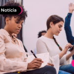 Pessoas em sala anotando em caderno.