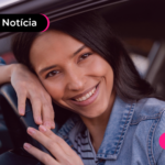 Pessoa em carro com expressão feliz.