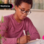 Pessoa escrevendo em folha.