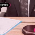 Pessoa de terno assinando em documento.
