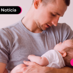 Homem segurando bebê nos braços.