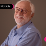 Aposentado sorrindo enquanto lê notícia sobre aumento salarial.