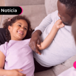 Criança sorridente brincando com os pais.