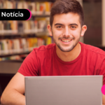 Pessoa com notebook sorrindo.