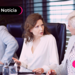 Pessoas de terno debatendo em sala de reunião.