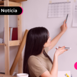 Mulher olhando calendário em parede.
