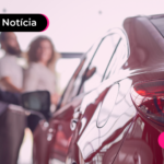 Pessoas olhando para carro vermelho.