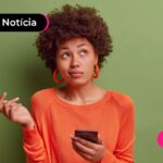 Pessoa com cara de dúvida segurando celular.