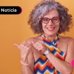 Pessoa idosa com expressão feliz apontando para o lado.
