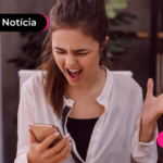 Mulher com expressão de raiva olhando para celular.