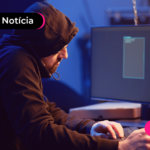 Pessoa de moletom mexendo em computador.