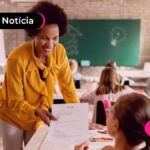 Professora sorrindo em sala de aula.