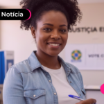 Mulher sorrindo enquanto vota nas eleições.