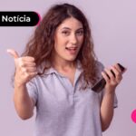 Jovem feliz enquanto lê notícia sobre pagamento do segundo lote do PIS/PASEP de 2026.