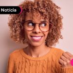 Jovem sorrindo enquanto lê notícia sobre novo título do tesouro direto.