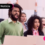 Pessoas em rua segurando cartazes.
