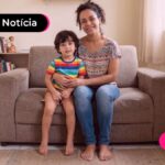 Mão e filho sentados em sofá.