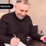 Idoso fazendo anotações das dívidas quitadas com consignado
