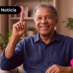 Pessoa de idade sorrindo ao ler notícia sobre adiantamento do décimo terceiro.