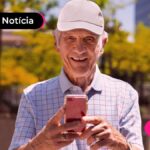Idoso mexendo no celular.