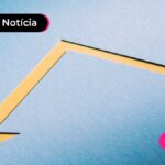 Seta amarela apontando para baixo, indicando queda da Selic.