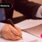 Pessoa assinando documentos onde o uso da IA terá restrições durante as eleições.