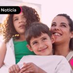 Mulher abraçada com duas crianças.