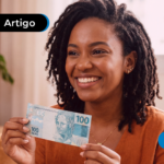Mulher jovem sorrindo ao segurar uma nota de 100R$.