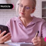 Mulher idosa olhando para celular.