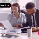 Pessoas de terno em escritório analisando papéis.