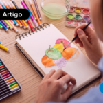 Pessoa com caderno e vários lápis de colorir desenhando em curso de desenho.
