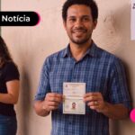 Homem em fila de eleição segurando documentos para votar.