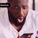 Homem olhando surpreso para celular.