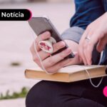 Pessoa segurando bíblia e celular.