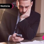 Homem chateado olhando celular.