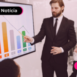 Homem de terno apresentando gráfico para pessoas.
