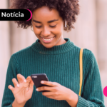 Moça sorrindo mexendo no celular.