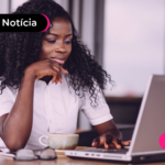 Jovem usando notebook para ler notícia sobre automatização anual do Imposto de Renda.