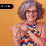 Aposentada feliz após ler notícia sobre leilão digital do INSS.
