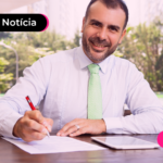 Homem assinando documento.