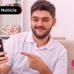 Homem apontando para celular.