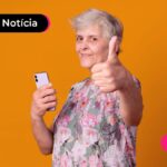 Idosa fazendo positivo com a mão pós receber decimo terceiro do INSS.
