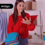 Menina vestida de vermelho segurando roupas em uma mão e um tablet na outra.