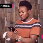 Homem lendo nota fiscal com celular.